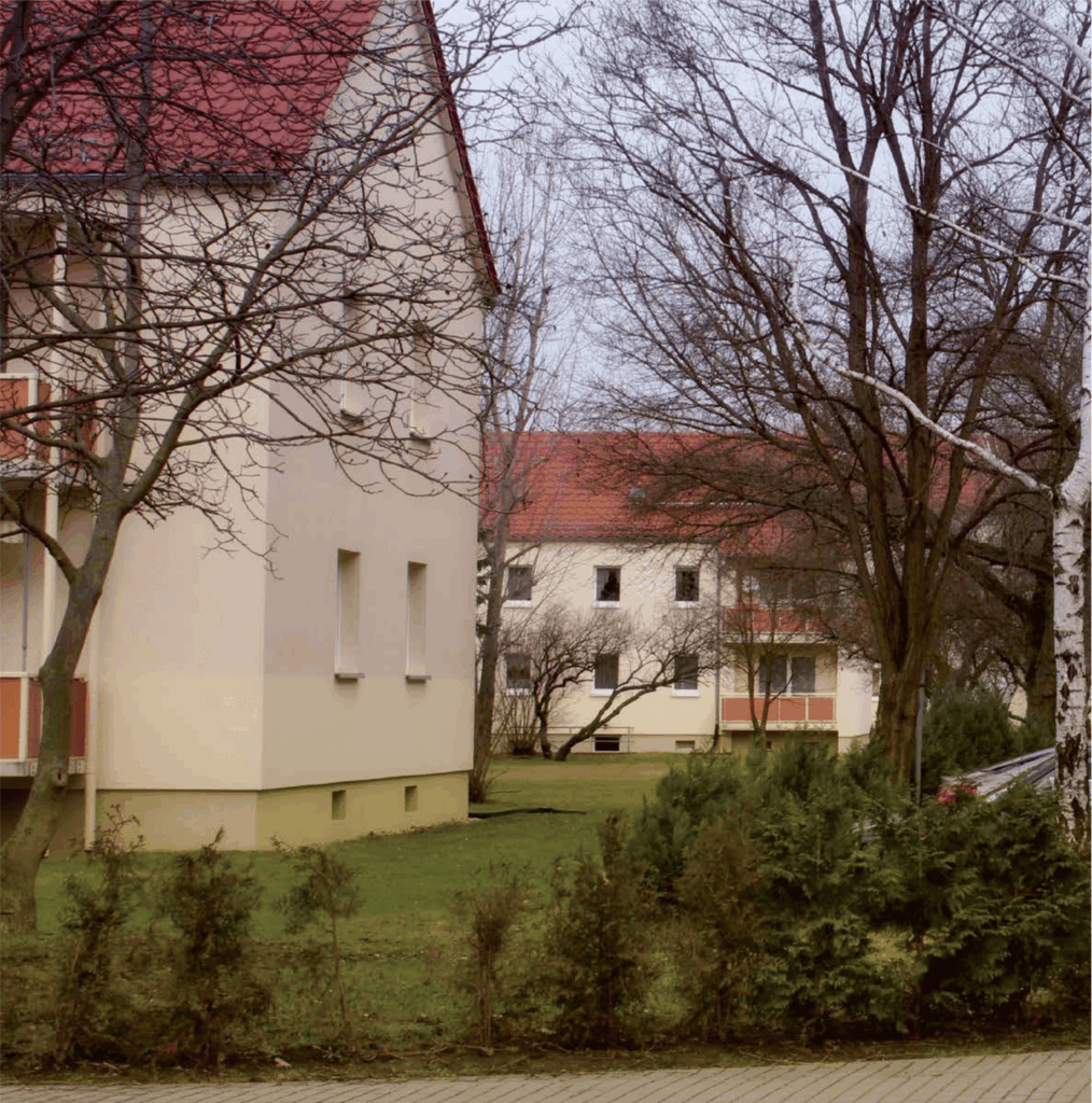 Wohnanlage mit Grünflächen und roten Dächern | Residential complex with green areas and red roofs